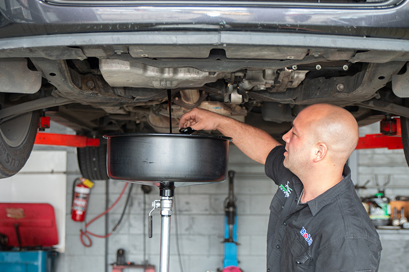 Brad changing the oil of a car